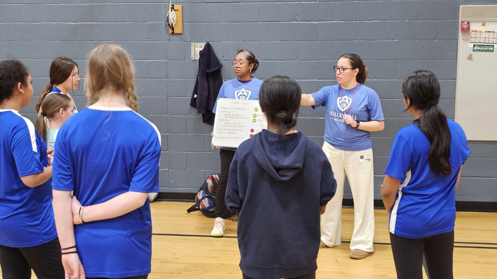 VA coach working with players at a whiteboard